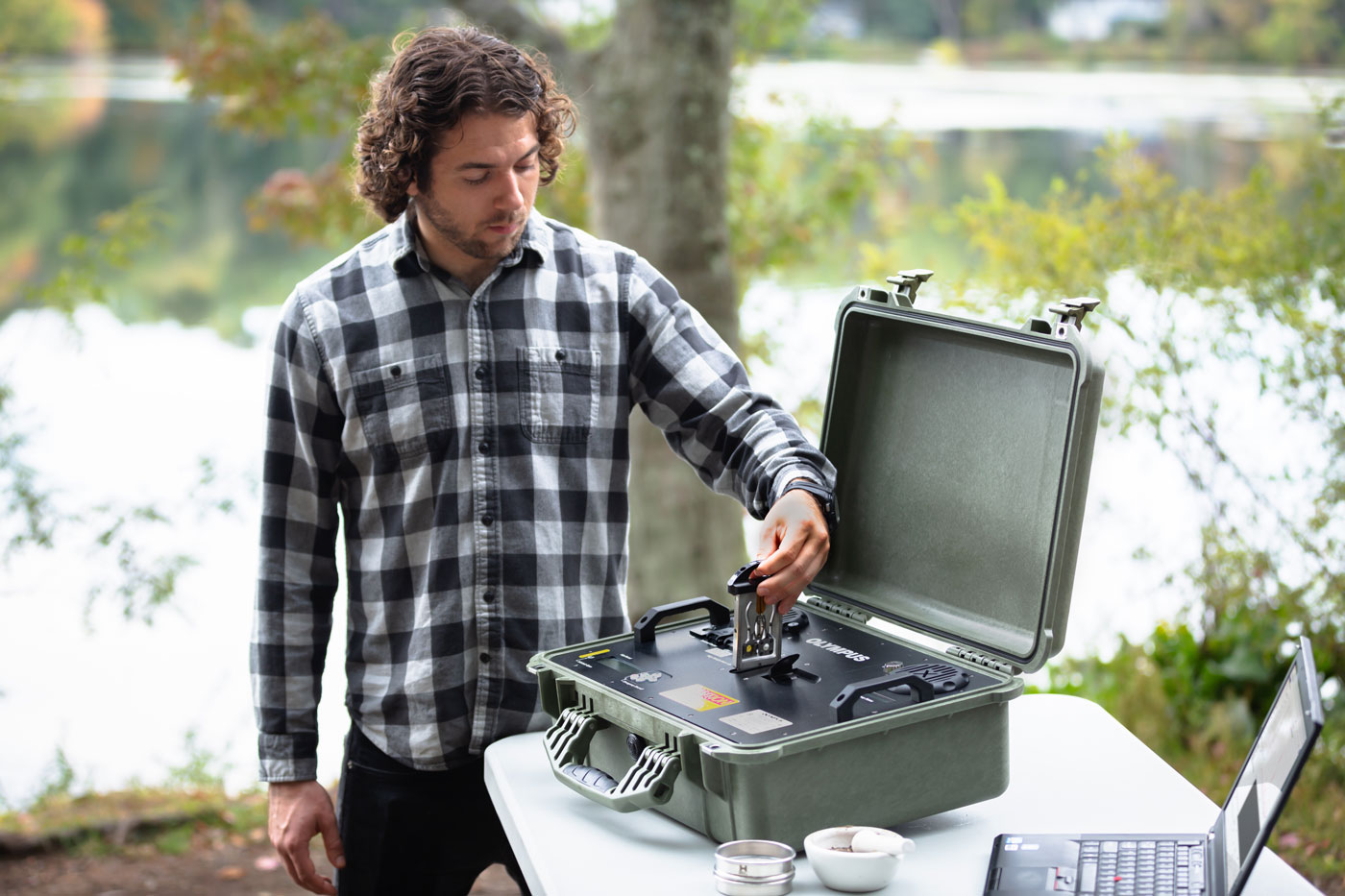 在野外检测中，TERRA XRD分析仪的用户正在将准备好的样品插入样品舱。