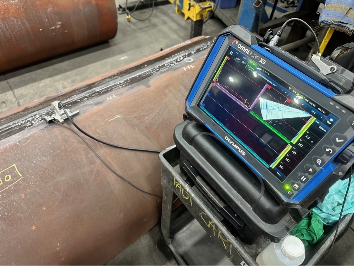detector being used to inspect a weld in a metal pipe.