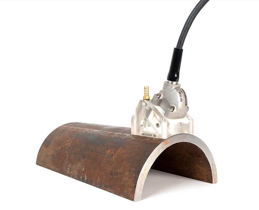 相控阵探头和被动轴聚焦楔块组合件正在检测半个管材，这种检测配置可以补偿因管道表面和底面的曲率而引起的声束发散现象。