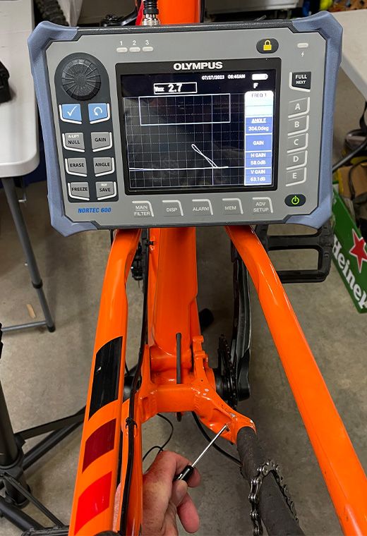 说明文字：在自行车车架的裂纹区域进行涡流扫查